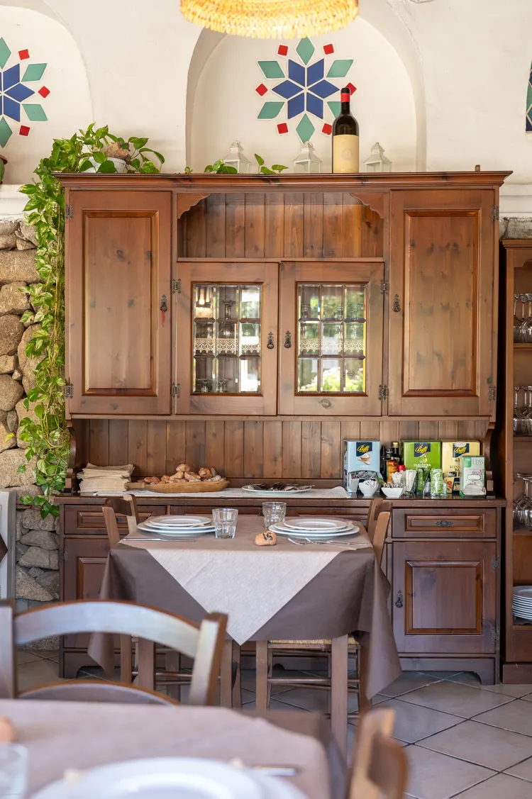 The indoor dining room with a wooden dresser and set tables